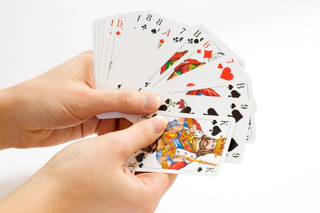 Una mano che sistema le carte da gioco a ventaglio